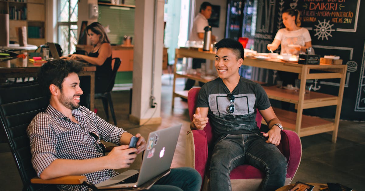 Two men enjoying a relaxed conversation with laptops in a cozy Brazilian café.